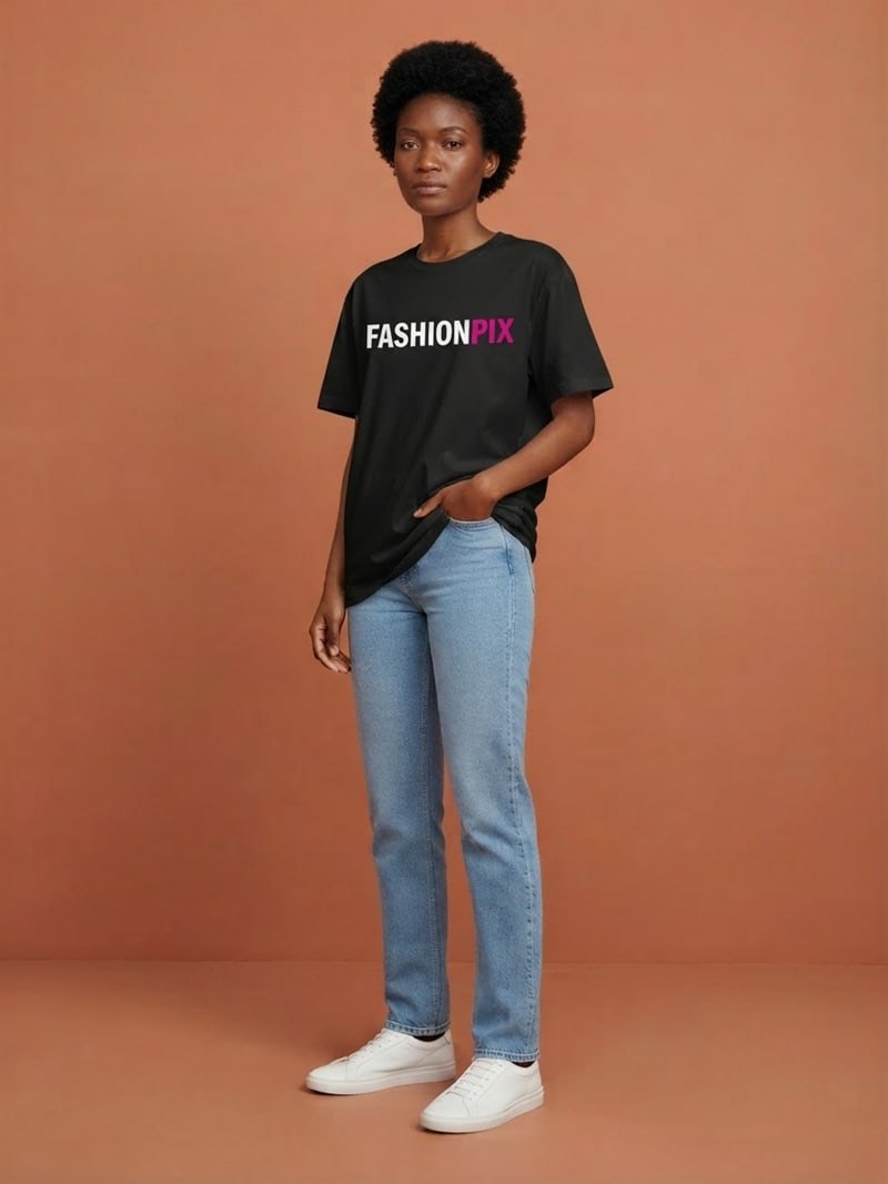 Amara, een jonge vrouw met korte natuurlijke afro, driekwart in de studio in het FASHIONPIX-T-shirt met de hand in de zak